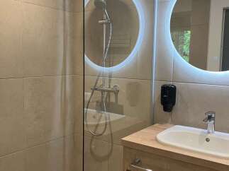 This modern bathroom features a walk-in shower with sleek glass enclosure, enhancing the sense of space.