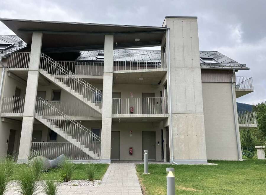 This modern apartment building boasts exterior staircases and balconies for each unit, offering both convenience and private outdoor spaces.