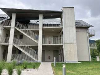 This modern apartment building boasts exterior staircases and balconies for each unit, offering both convenience and private outdoor spaces.