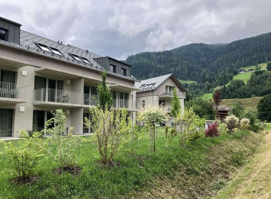 These modern apartments offer a serene retreat with balconies overlooking lush greenery and mountain views.