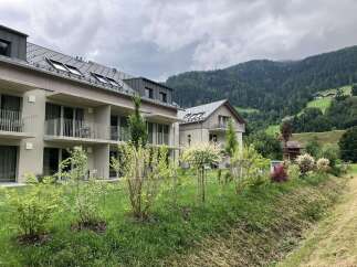 These modern apartments offer a serene retreat with balconies overlooking lush greenery and mountain views.