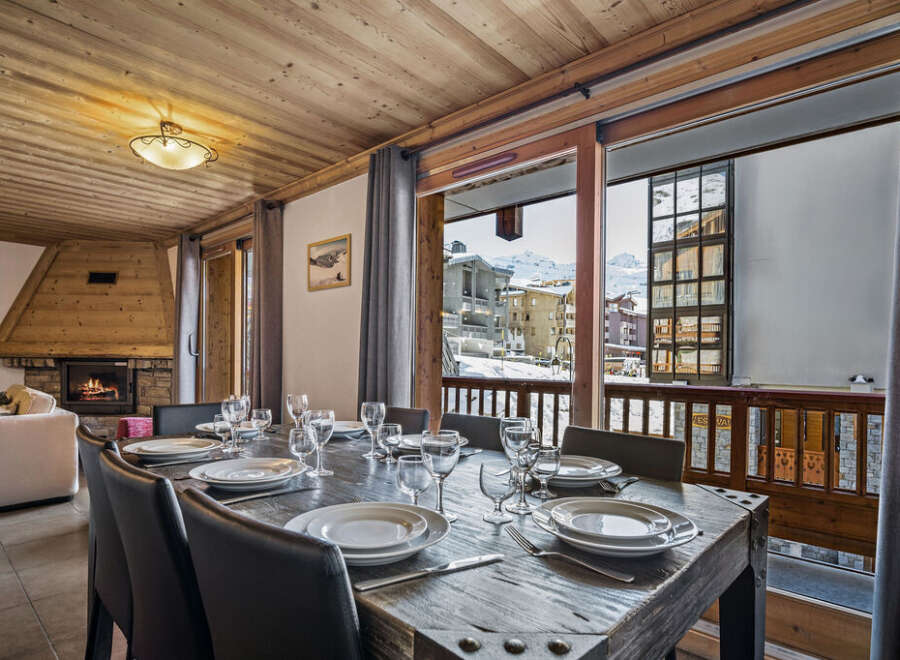 This inviting dining area boasts a beautifully set table perfect for meals with a view.