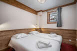 This inviting bedroom features two twin beds with crisp white linens and plush towels, perfect for a cozy stay.