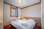 This inviting bedroom features two twin beds with crisp white linens and plush towels, perfect for a relaxing stay.