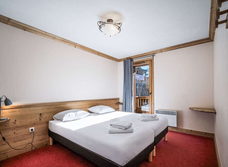 A cozy bedroom featuring twin beds with crisp white linens and a wooden headboard.
