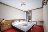 A cozy bedroom featuring twin beds with crisp white linens and a wooden headboard.