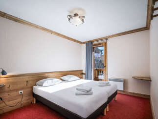 A cozy bedroom featuring twin beds with crisp white linens and a wooden headboard.