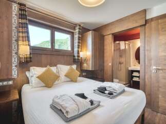 This inviting bedroom features warm wood paneling, creating a cozy, rustic ambiance.