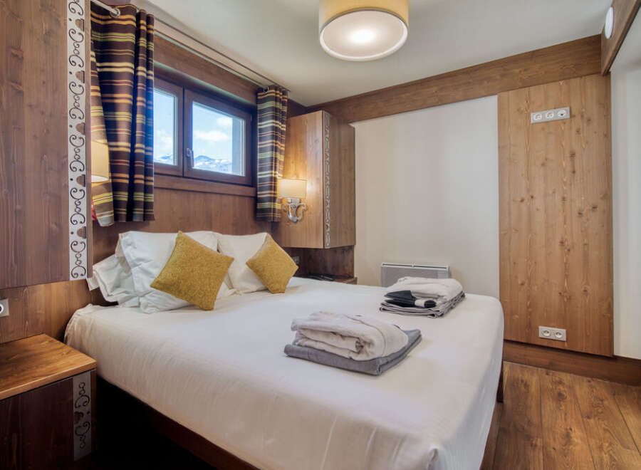 A cozy bedroom features wood-paneled walls, creating a warm and inviting ambiance.