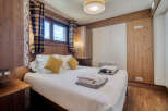 A cozy bedroom features wood-paneled walls, creating a warm and inviting ambiance.