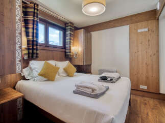 A cozy bedroom features wood-paneled walls, creating a warm and inviting ambiance.