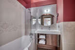 This bathroom features a modern design with a bathtub, shower, sink, and mirror.