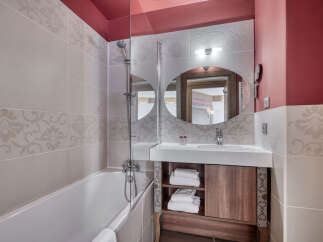 This bathroom features a modern design with a bathtub, shower, sink, and mirror.