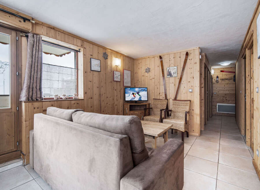 Discover this charming ski chalet-style living room, featuring cozy wood-paneled walls that create a warm and inviting atmosphere.
