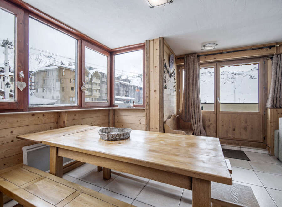 This room features a wooden table and bench seating perfect for enjoying meals with mountain views.