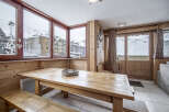 This room features a wooden table and bench seating perfect for enjoying meals with mountain views.