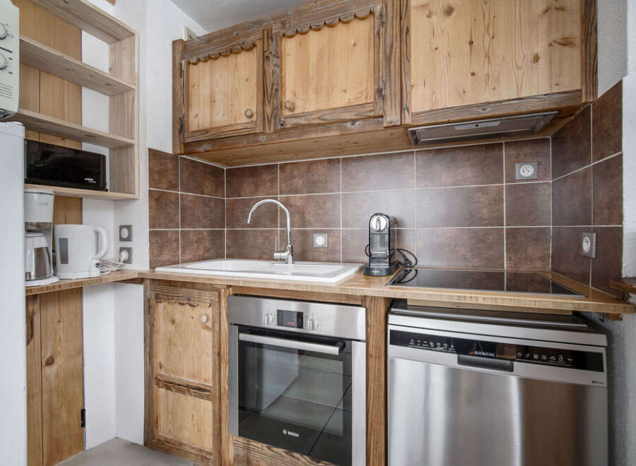 This kitchen features rustic wooden cabinetry and modern stainless steel appliances.