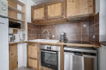 This kitchen features rustic wooden cabinetry and modern stainless steel appliances.