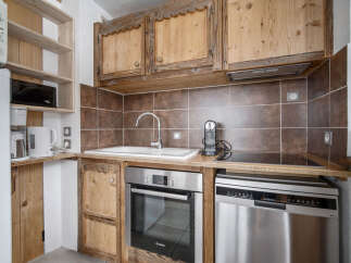 This kitchen features rustic wooden cabinetry and modern stainless steel appliances.