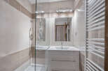 This modern bathroom features stylish beige and white tiling, creating a warm and inviting atmosphere.