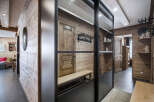Discover a cozy chalet featuring natural wood walls, a stylish metal and glass partition, and unique decor elements.