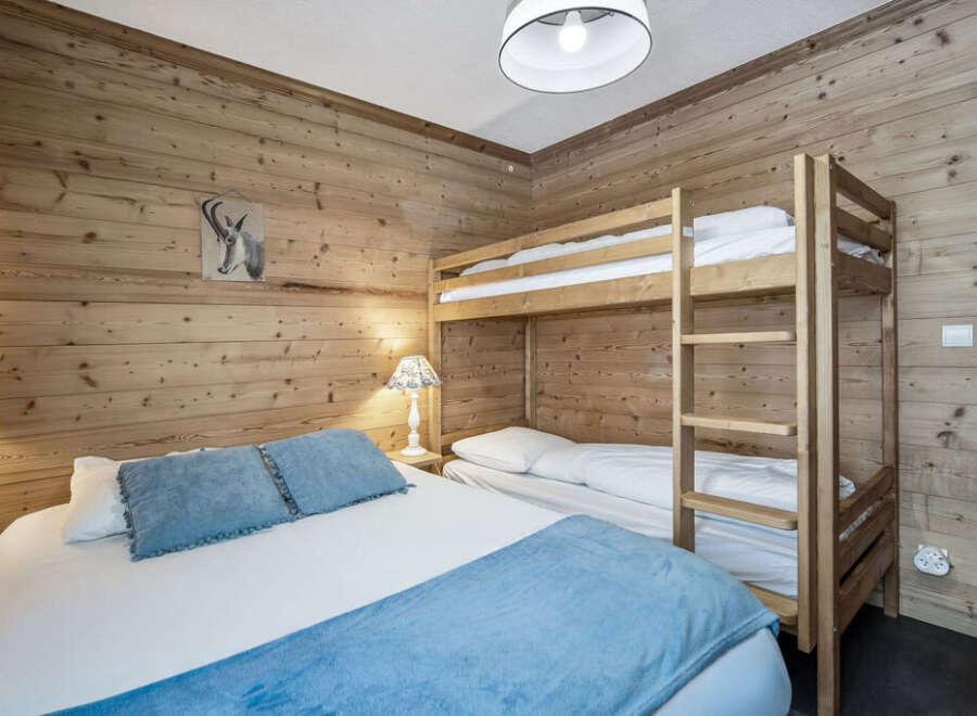 This cozy bedroom features rustic wooden walls that create a warm and inviting atmosphere.
