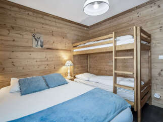 This cozy bedroom features rustic wooden walls that create a warm and inviting atmosphere.