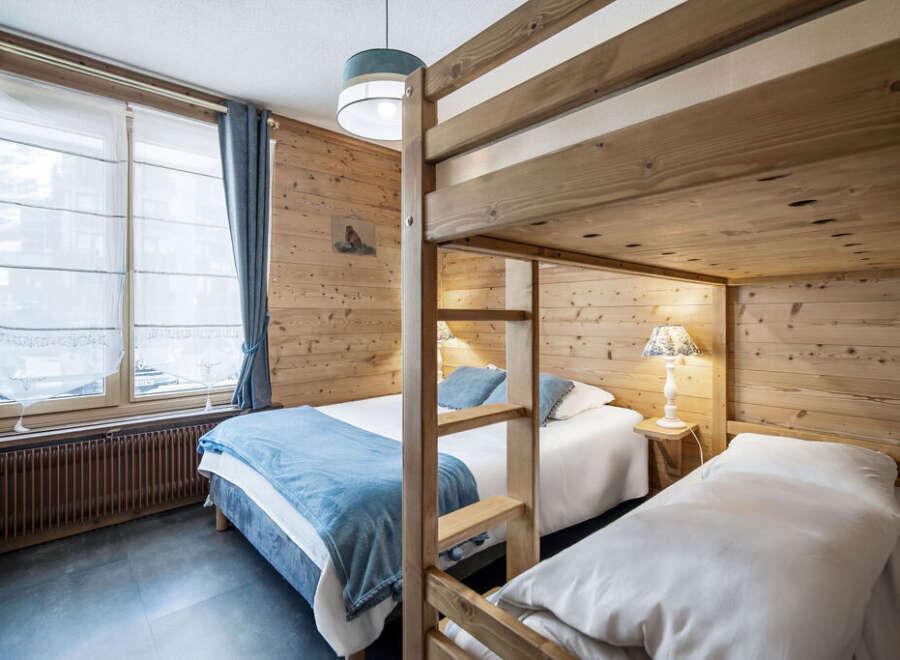 This cozy bedroom features charming wood paneling, creating a warm and inviting atmosphere.