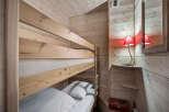 This cozy bunk room features a wooden bunk bed with crisp white linens, perfect for a vacation rental or family home.