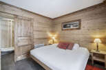 This inviting bedroom features warm wood paneling, creating a cozy, chalet-style atmosphere.