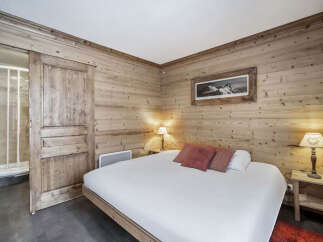 This inviting bedroom features warm wood paneling, creating a cozy, chalet-style atmosphere.