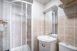 This bathroom features a glass-enclosed shower and a vanity with a marble countertop.