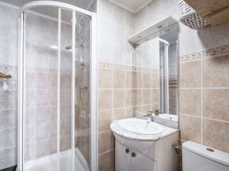 This bathroom features a glass-enclosed shower and a vanity with a marble countertop.