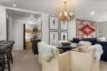 This stylish living space features a unique antler chandelier, a cozy dining area with fur-covered chairs, and a comfortable lounge area with a vibrant patterned rug.