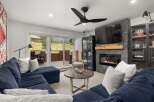 This inviting living room boasts a cozy fireplace with a stone surround, perfect for relaxing evenings.