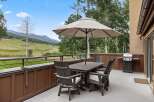 Enjoy outdoor dining with a view from this property's deck, complete with a dining table, chairs, and umbrella for shade.