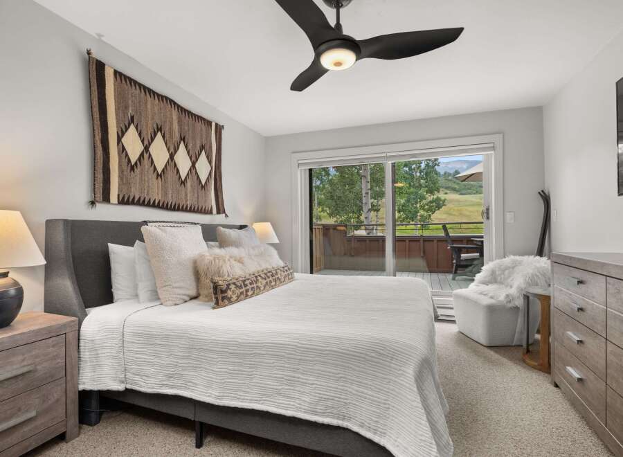 This inviting bedroom offers a comfortable retreat with its plush bed, soft lighting, and elegant wooden furniture.