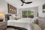 This inviting bedroom offers a comfortable retreat with its plush bed, soft lighting, and elegant wooden furniture.
