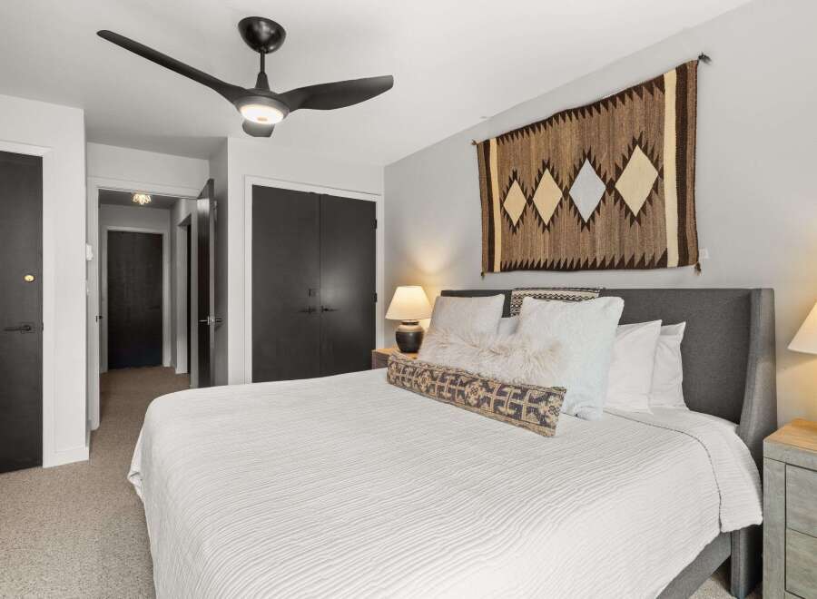 This bedroom features a comfortable bed with soft white linens and decorative pillows.