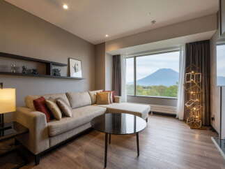 This inviting living room boasts a comfortable sectional sofa, perfect for relaxing and enjoying the stunning mountain views through the expansive window.
