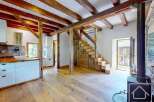 Discover a unique alpine property featuring exposed wooden beams, a cozy fireplace, and custom wooden stairs.