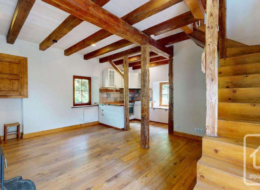 Rustic charm meets modern living in this unique property featuring exposed wooden beams, hardwood floors, and a cozy wood-burning stove.