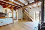 This inviting property boasts a rustic charm with exposed wooden beams and hardwood floors.