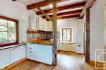 Step inside this charming kitchen, featuring rustic wooden beams and pristine white cabinetry.