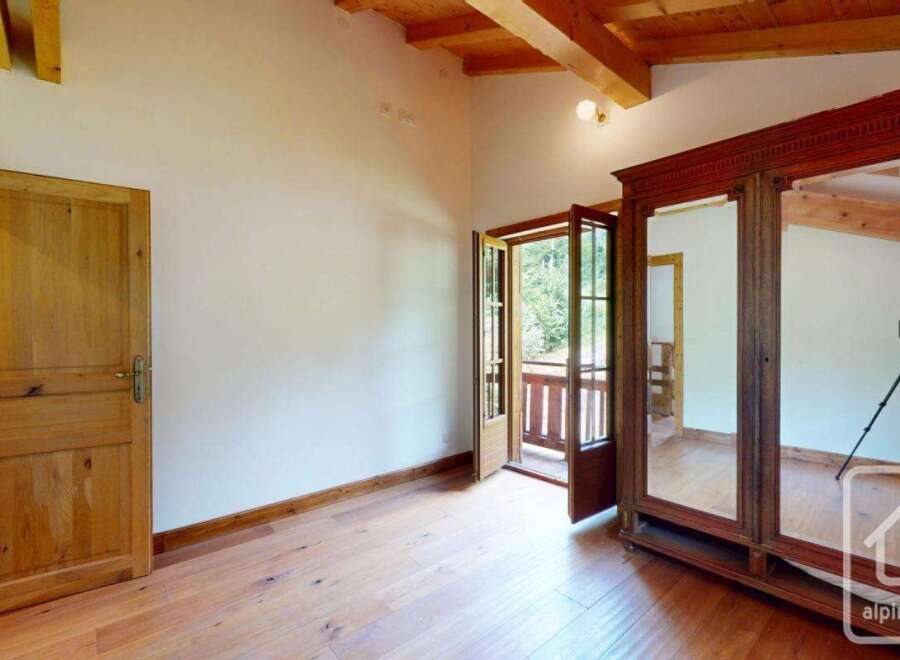 This room features beautiful wooden floors, a rustic wooden ceiling, and a classic wooden wardrobe.