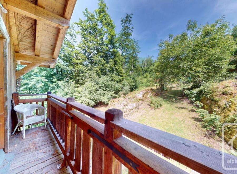 This property boasts a charming wooden balcony with scenic views of lush greenery.