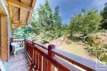 This property boasts a charming wooden balcony with scenic views of lush greenery.
