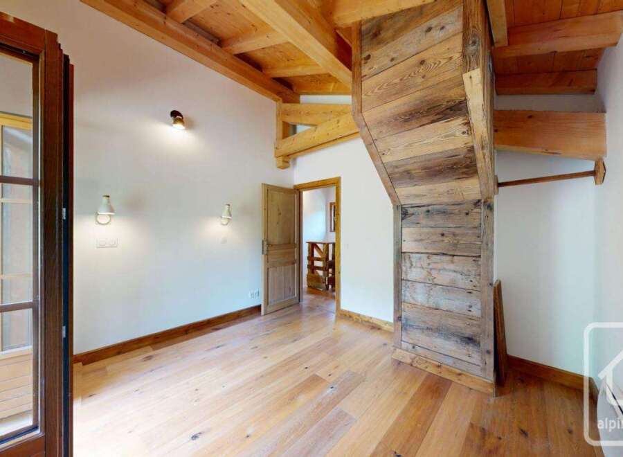 This property boasts a bright and airy room featuring a beautiful wooden floor and ceiling, creating a warm and inviting atmosphere.
