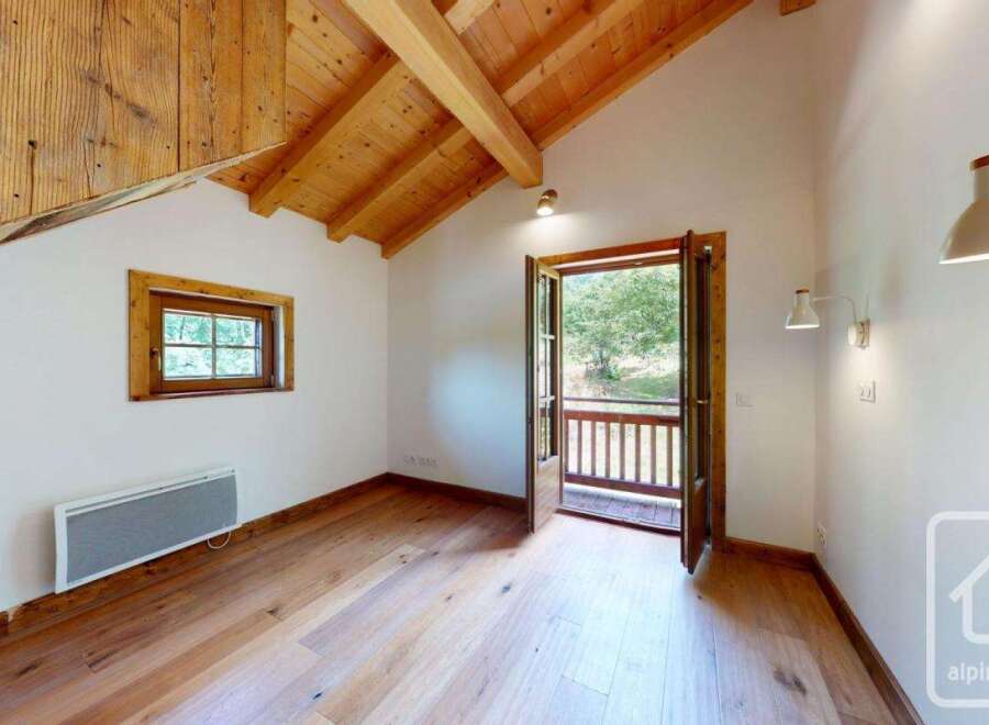 This bright and airy room features a stunning wood-beamed ceiling and natural wood flooring, creating a warm and inviting space.