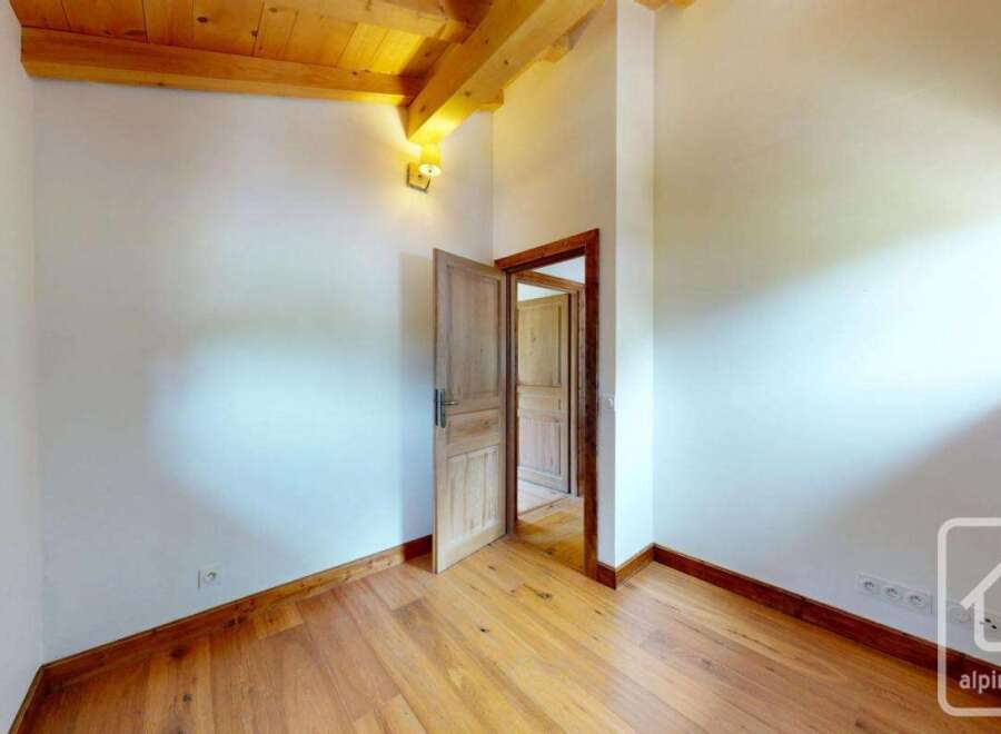 This inviting room boasts a warm ambiance with its wooden floors and ceiling beams.